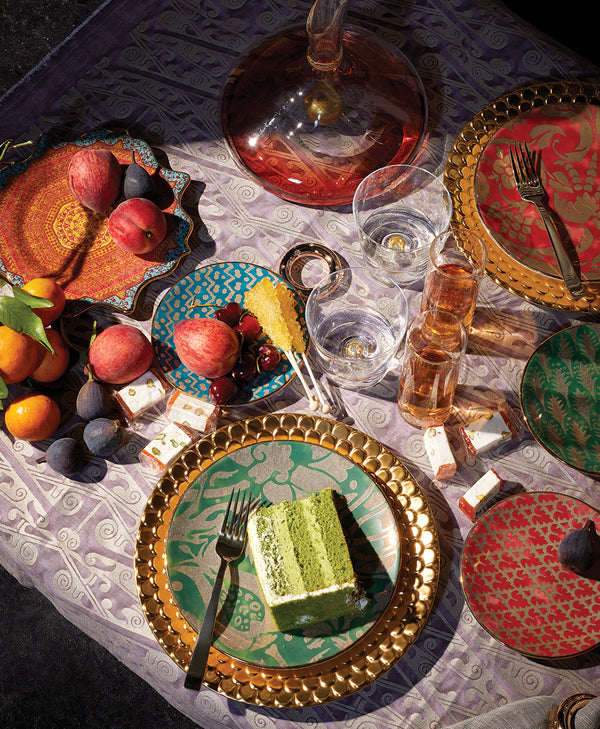 Colorful and pattern Dinnerware arranged in a table setting with fruit and glassware