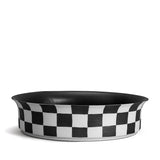 Black and white checkerboard glaze pattern on a low, round porcelain bowl with a flared rim shape.