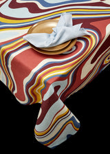 Linen rectangular tablecloth with an organic, psychedelic pattern in red, blue, yellow and ivory hues.