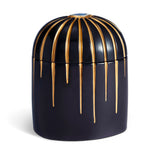 Dark blue cylinder candle posed from side to show gold drip details from eye motif