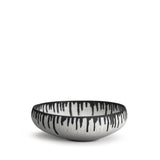 A handmade porcelain decorative bowl with indigo dye drops to flowing down from the rim.