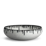 A handmade porcelain decorative bowl with indigo dye drops to flowing down from the rim.