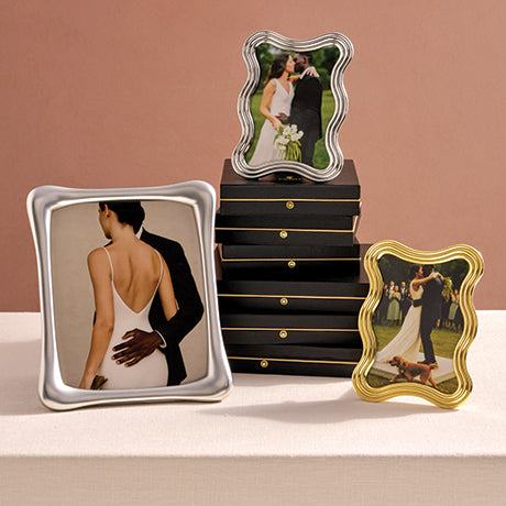 Three decorative photo frames with different designs on a beige surface.