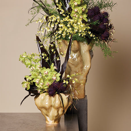 Two decorative vases with floral arrangements on a neutral background