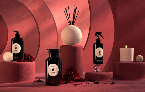3D illustrated scene depicts surreal, oversized Rose Noire apothecary products- lotion, room spray, bath salt and lit candle