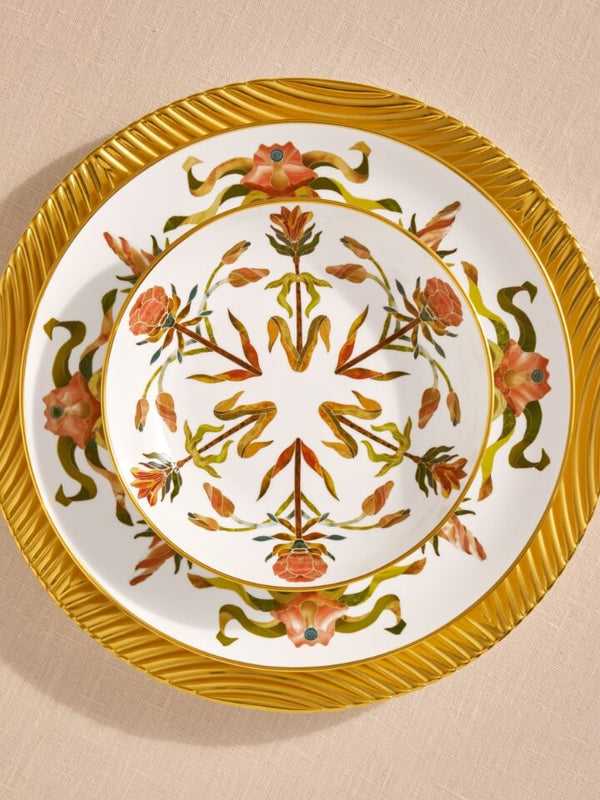 Decorative plate with floral patterns and gold rim on a beige background