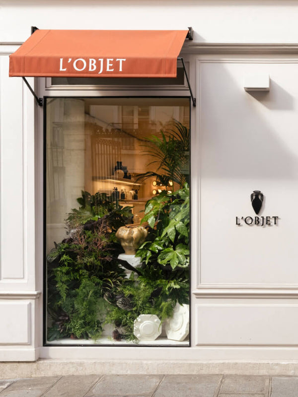 L'Objet store front with decorative plants and a red awning.