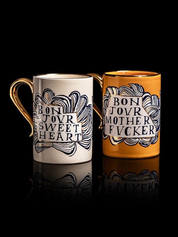 Two mugs with text design on a black background