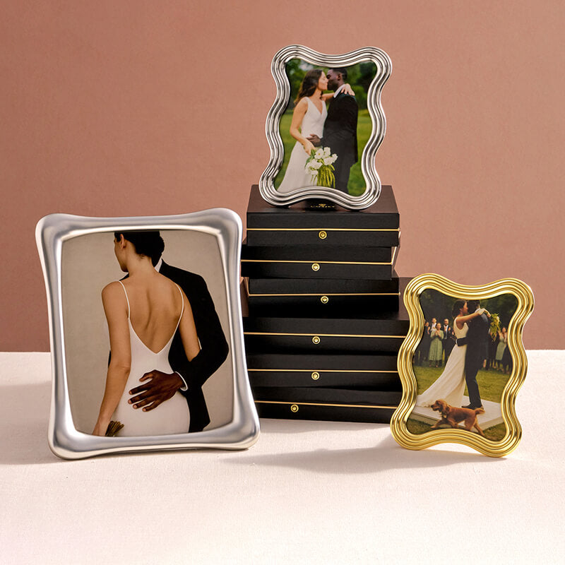 Three decorative photo frames with wedding images on a pink background