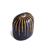 Dark blue cylinder candle with gold details dripping from top eye motif
